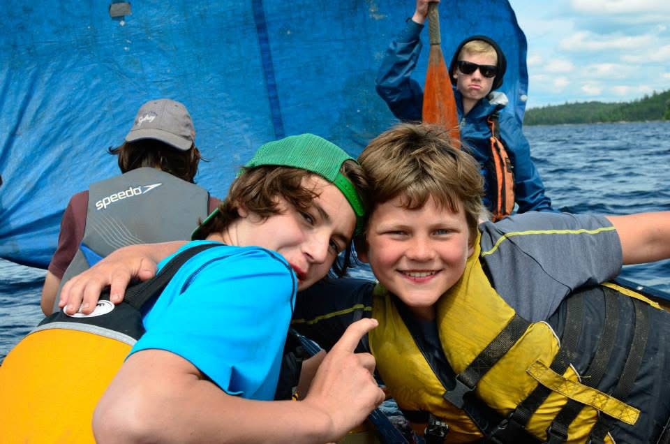 Two campers smiling on the water at summer camp